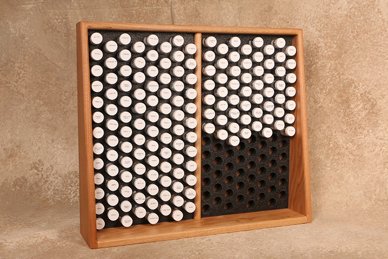Wooden display case holding rows of labeled Standard Process test vials